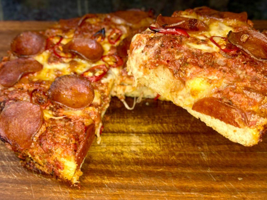 Slice of crispy fluffy cast iron pan pizza