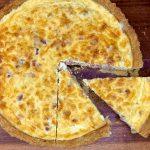 Quiche lorraine with a slice taken out.