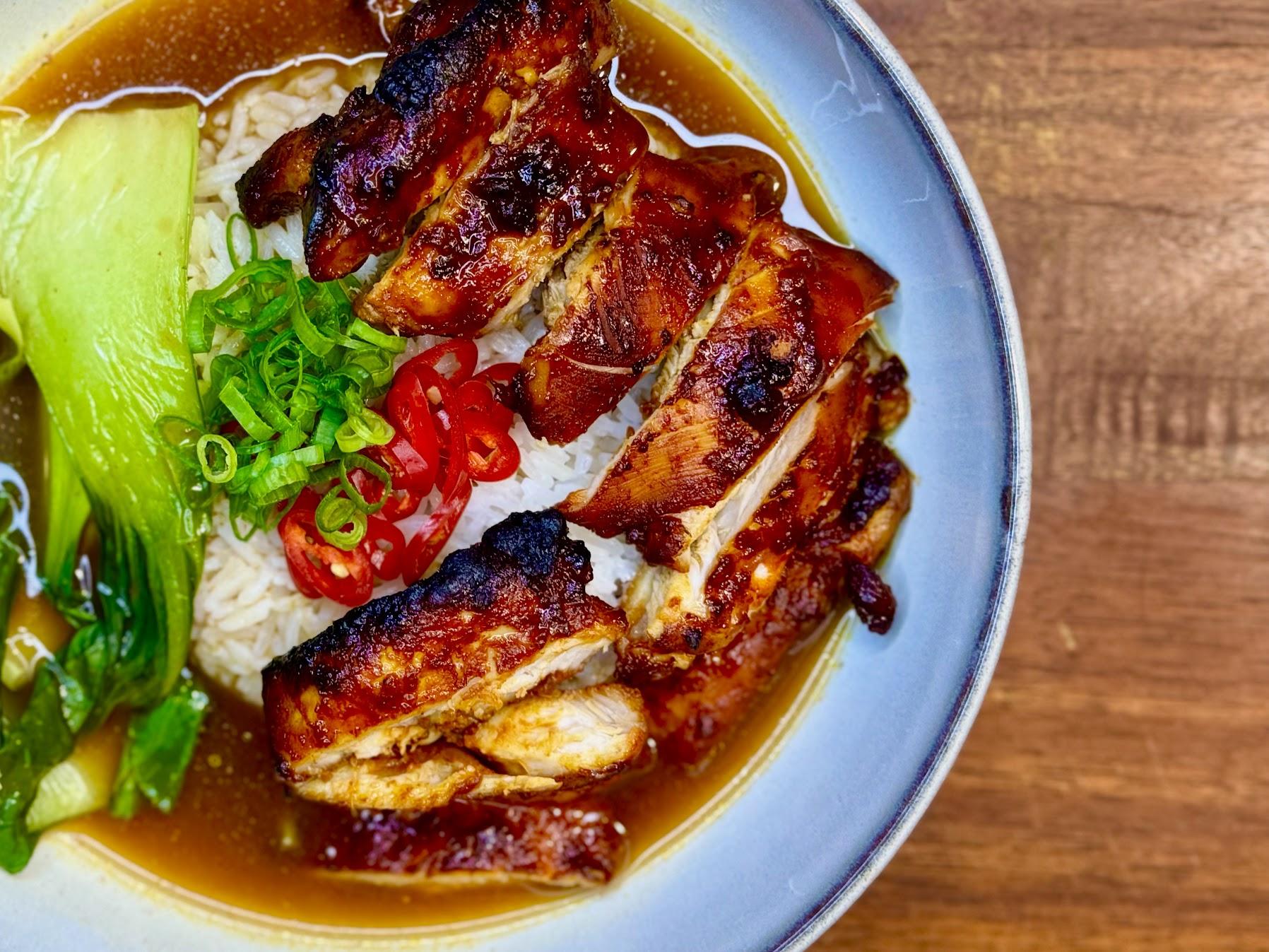 Bowl of gochujang chicken, rice, gochujang broth and pak choi