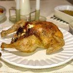 Roast chicken on a table full of food.