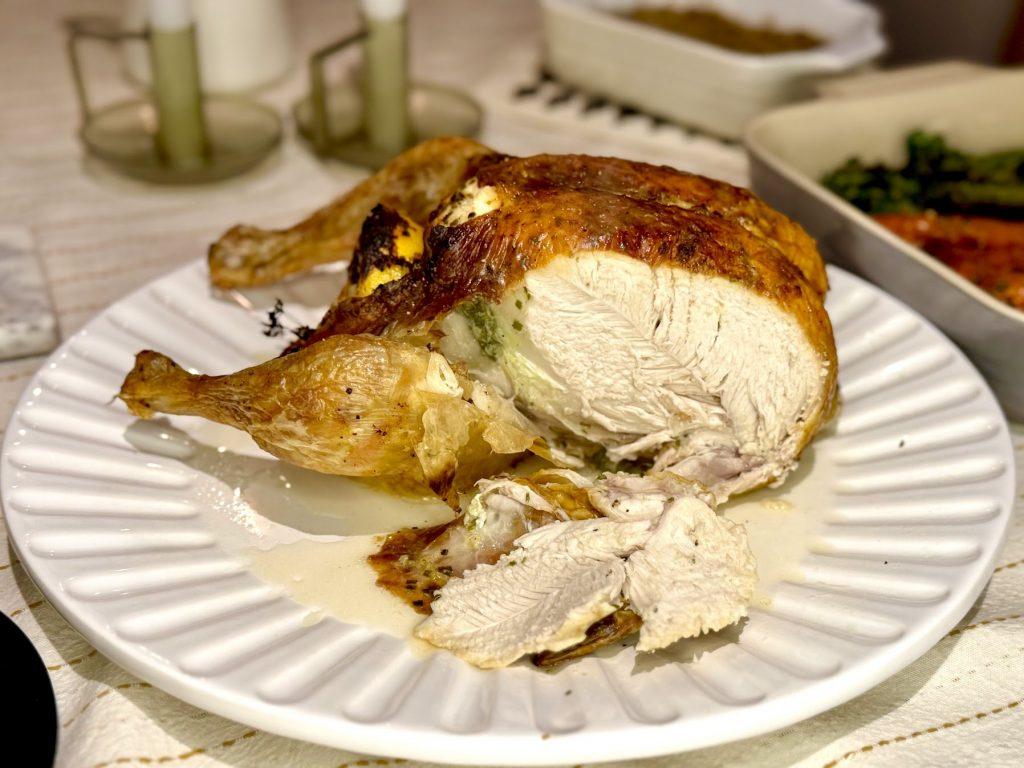 Sliced roast chicken on a table full of food.