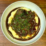 Bowl of slow cooked beef shin in red wine sauce on mustard mashed potatoes