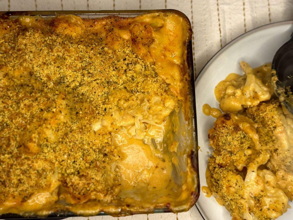 Spiced cauliflower cheese with a herby crumb spooned onto a plate
