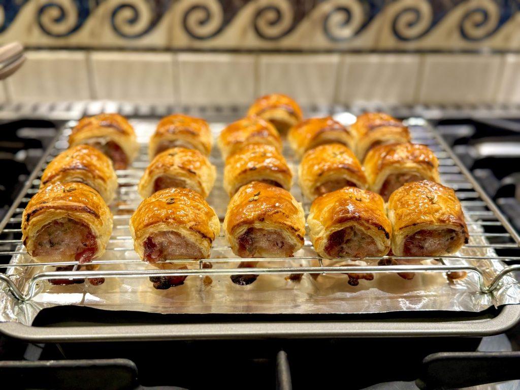 A tray of festive sausage an cranberry rolls on the hob.