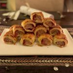 A plate of festive pork & cranberry sausage rolls served on a festive table
