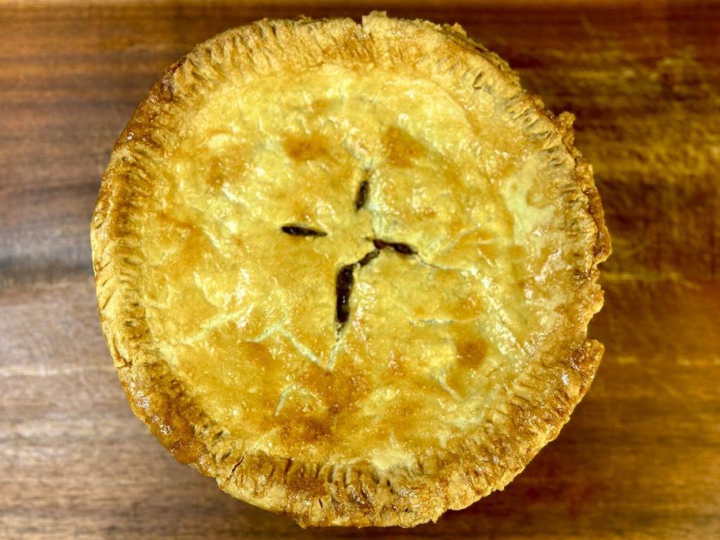 Steak & ale pie on a wooden chopping board