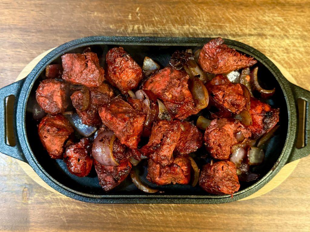 Sizzling dish of chicken tikka and onions