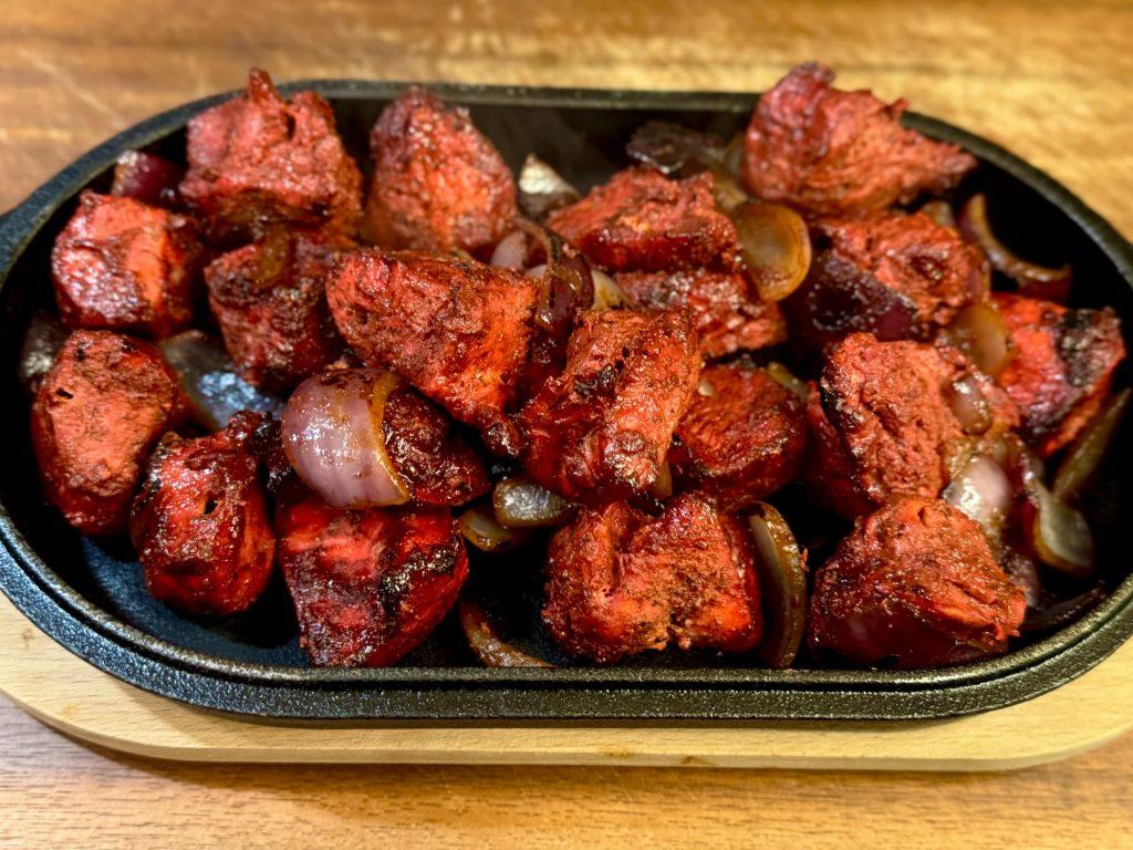 Sizzling dish of chicken tikka and onions