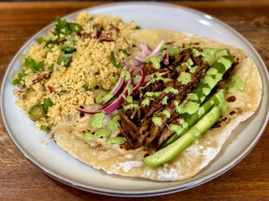 Slow cooked shawarma lamb leg on homemade lflat breads with couscous