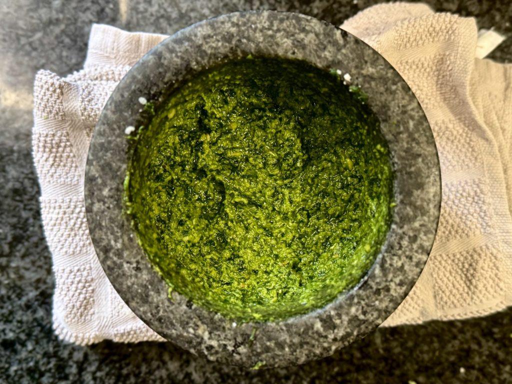 Mortar full of pesto, sitting on a towel